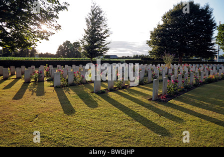 Sonnenuntergang über sonnenbeschienene Grabsteine auf dem Commonwealth War Graves Cemetery in Bayeux, Frankreich. Stockfoto