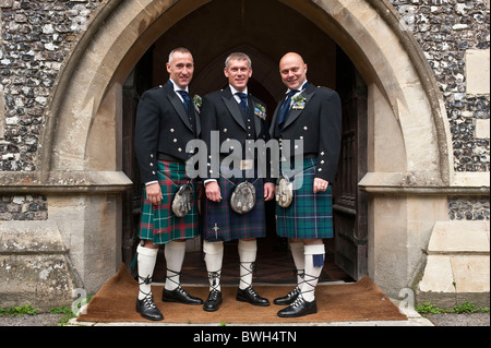 Horizontale close-up-Porträt von drei Männern in traditionelle schottische Kleidung außerhalb einer Kirche an einem Hochzeitstag. Stockfoto