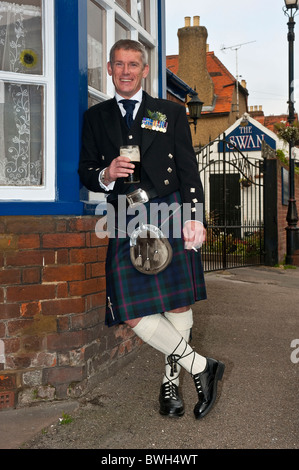 Vertikale Nahaufnahme Portrait eines Mannes in schottischer Tracht mit einem letzten Bier und Zigarette, bevor er heiratet. Stockfoto