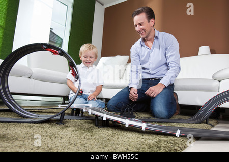 Vater und Sohn spielen mit Rennstrecke Stockfoto