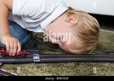 Jungen spielen mit Slot-Rennstrecke Stockfoto