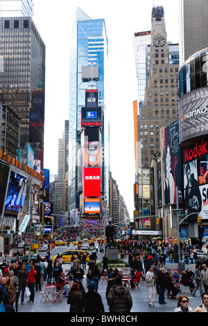 USA New York NYC Manhattan Menschen zu Fuß auf dem Times Square an der Kreuzung der 7th Avenue und Broadway mit Werbung Bildschirme Stockfoto