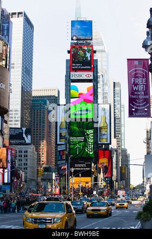 USA, New York, Manhattan, Menschen zu Fuß auf dem Times Square an der Kreuzung der 7th Avenue und Broadway unter Werbung Bildschirme Stockfoto