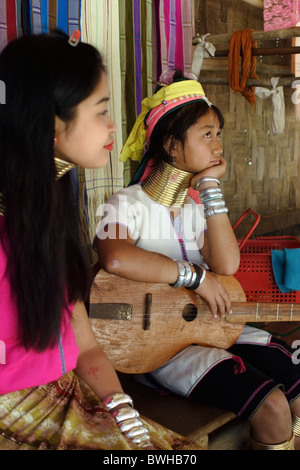 Zwei Karen Paduang Flüchtlinge sitzen vor ihrem Haus in Ban Nai Soi, Thailand. Stockfoto