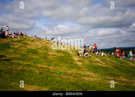 Menschen sitzen auf dem Hügel an der Spitze der Park-Bühne beim Glastonbury Festival 2010 Stockfoto