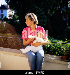 HERR JUNGE MUTTER MIT DER FLASCHE FÜTTERN IHRE TOCHTER BABY Stockfoto