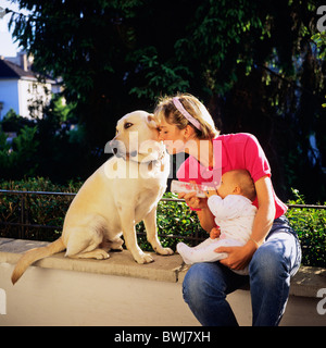 HERR JUNGE MUTTER MIT DER FLASCHE FÜTTERN IHR BABY UND LABRADOR GOLDEN RETRIEVER HUND Stockfoto