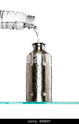 gießt Wasser aus einer Plastikflasche in ein Metall Flasche Stockfoto