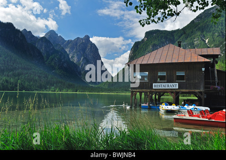 Restaurant und Pedal Boote entlang des Sees Lago di Dobbiaco / Toblacher See in den Dolomiten, Italien Stockfoto