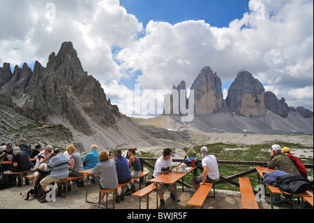 Touristen auf der Terrasse von der Dreizinnenhütte / Rifugio Antonio Locatelli und Tre Cime di Lavaredo / Drei Zinnen, Dolomiten, Italien Stockfoto