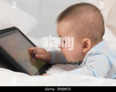 Sechs Monate altes Baby junge spielt mit einem Tablet-computer Stockfoto
