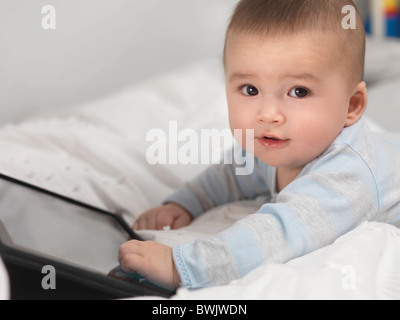 Sechs Monate altes Baby junge spielt mit einem Tablet-computer Stockfoto