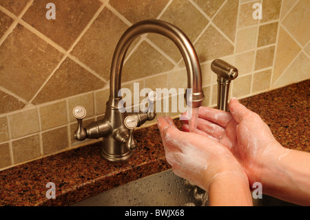 Seifigen Hand waschen unter fließendem Wasser aus einer Küche Wasserhahn Stockfoto