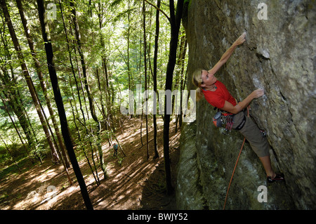 Frau Klettern auf einer Felswand in den Wald, Fränkische Schweiz, Bayern, Deutschland, Europa Stockfoto