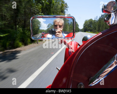 Blick vom offenen MG Sportwagen der geraden Straße voraus mit Fotograf spiegelt sich in den seitlichen Spiegel Stockfoto