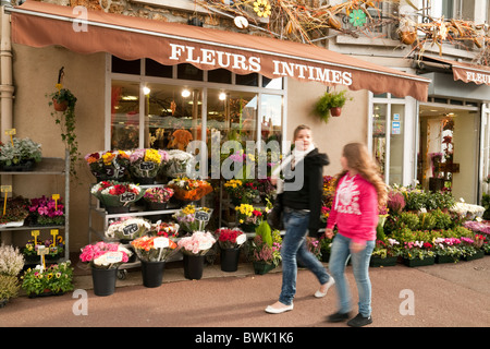 Zwei Mädchen im Teenageralter vorbei an einem Blumenladen in Meaux, Ile-de-France, Frankreich Stockfoto