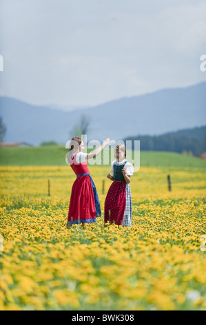 Zwei Mädchen auf Wiese von Löwenzahn, Antdorf, Oberbayern, Deutschland Stockfoto