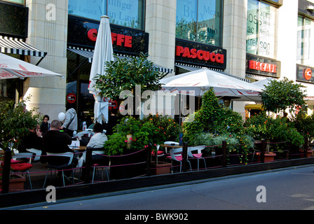 Gäste unter Sonnenschirmen im Café im freien Bürgersteig Patio in Leipzig Altstadt shopping zone Stockfoto