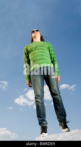 Porträt von lässig gekleideten Mann im Hochsprung gegen strahlend blauen Himmel Stockfoto