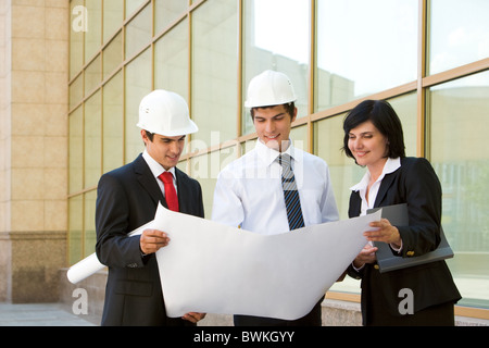 Bild der Gruppe von drei Arbeitern ihre Arbeit gemeinsam zu planen Stockfoto