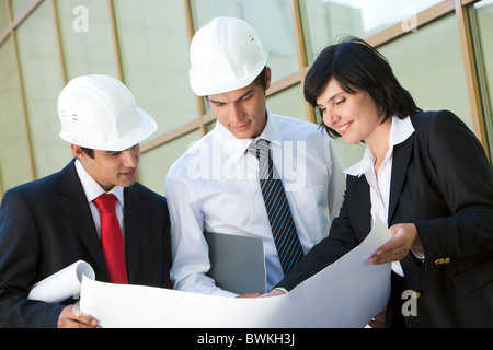 Bild der Gruppe von drei Arbeitern ihre Arbeit gemeinsam zu planen Stockfoto