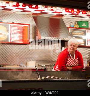 Gelangweilte Frau auf einem Burger Stall auf Aberystwyth Messe, Montag, 15. November 2010 Stockfoto