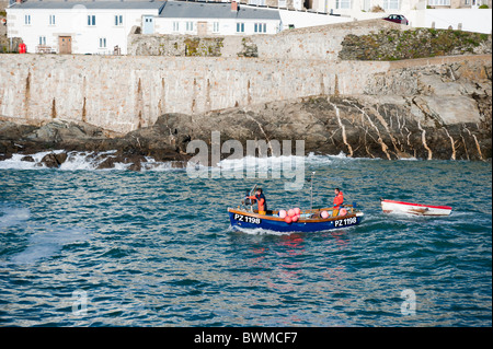 Porthleven Cornwall November 2010 während der "Nebensaison". Ein Fischerboot Abschleppen eine Ausschreibung verlässt den Hafen Stockfoto