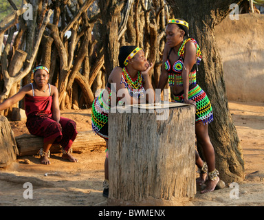 Zulu Mädchen in traditionellen Perlen Kostüme spielen ein Brettspiel mit Steinen, Shakaland Zulu-Dorf, Kwazulu Natal, Südafrika. Stockfoto