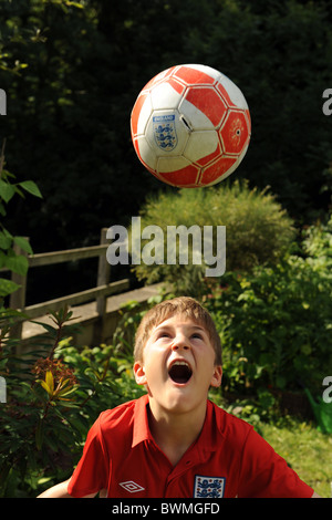 Ein zehn Jahre alter Junge spielt Fußball im Garten voll Modell freigegeben/zugestimmt Stockfoto