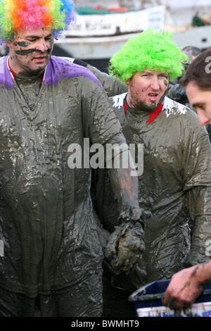 zwei Männer in Perücken bedeckt im Schlamm nach profiliert das Maldon-Schlamm-Rennen Stockfoto