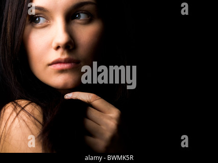 Bild der wunderschönen Dame mit dunklen Haaren mit der hand berühren und auf der Suche zur Seite Stockfoto