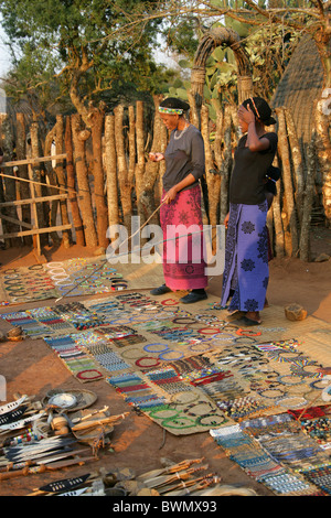 Zulu-Frauen mit Souvenirs an Touristen, Shakaland Zulu-Dorf, Nkwalini Tal, Kwazulu Natal, Südafrika. Stockfoto