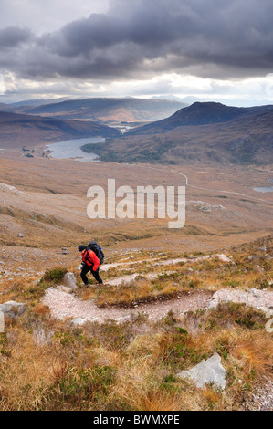 Walker aufsteigender Beinn Eighe mit Loch Clair in den Hintergrund, Torridon, Scotish Highlands Stockfoto