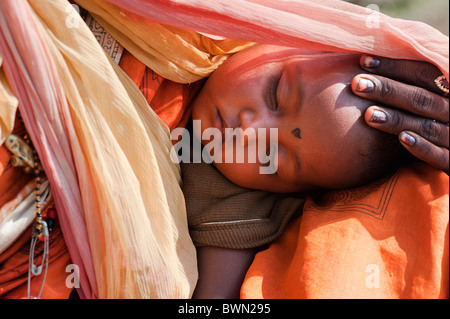 Ländlichen indischen Baby in den Müttern, die Schlinge vor der Sonne geschützt werden. Andhra Pradesh, Indien Stockfoto