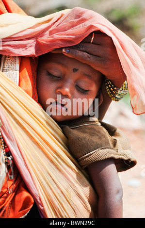 Ländlichen indischen Baby in den Müttern, die Schlinge vor der Sonne geschützt werden. Andhra Pradesh, Indien Stockfoto