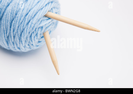 Studioaufnahme des blauen Wollknäuel mit Stricknadeln Stockfoto