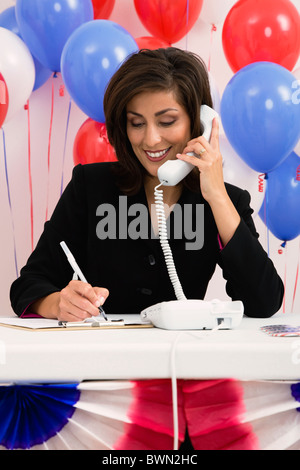 USA, Illinois, Metamora, Smiling Frau am Telefon, rot und blau Ballons im Hintergrund Stockfoto