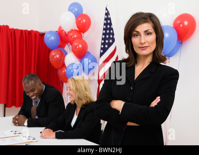 Porträt der Frau auf Abruf, Metamora, Illinois, USA platzieren, US-Flagge, Luftballons und Wahlkabine im Hintergrund Stockfoto