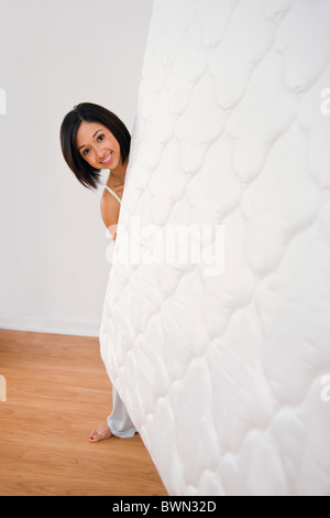 USA, Illinois, Metamora, junge Frau Holding Matratze und Blick in die Kamera Stockfoto