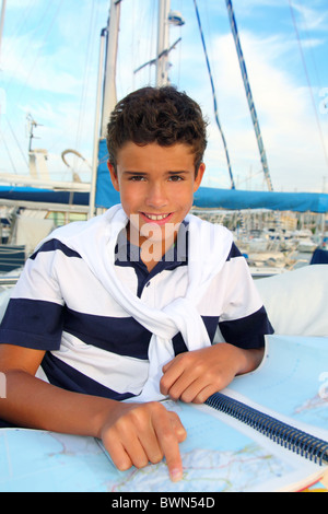 junge Teen Seemann sitzen auf Marina Boot Grafik Karte lächelnd in Sommerferien Stockfoto