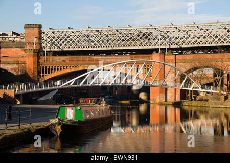 Viktorianische Eisenbahnbrücken, moderne Kaufleute Brücke, und Kanal 15-04, in Castlefield Becken, Manchester, England, Großbritannien Stockfoto