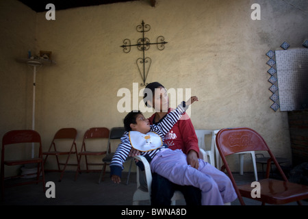 Adriana Lopez, 23, trägt ihre Tochter Citlali Gonzalez 6, der eine zerebrale Zyste in Mexiko-Stadt, 11. November 2010 leidet. Stockfoto