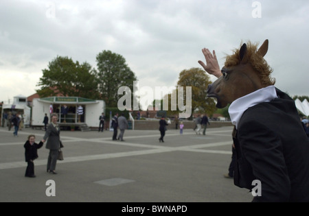 Person gekleidet wie ein Pferd in Newmarket Rennen winkt ein kleines Kind mit Elternteil Stockfoto