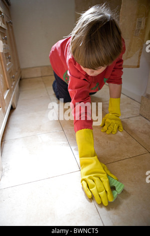 Acht Jahre alter Junge schrubben Fliese auf Badezimmerboden mit Latex Handschuhen, wöchentlichen Hausarbeit, USA. Stockfoto