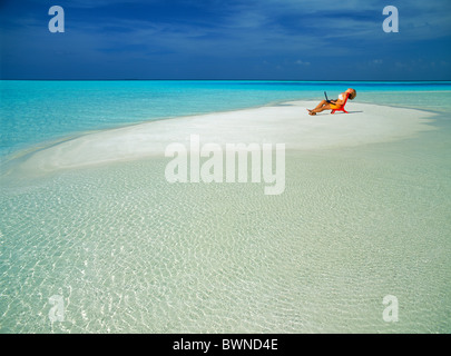 Frau sitzend im roten Stuhl entspannen Sie sich auf kleine Sandbank während Arbeitsurlaub in der Inselgruppe mit Laptop, Stockfoto