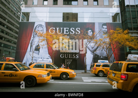 Ein Plakat auf einer Konstruktion, die Schuppen auf der Fifth Avenue in New York kündigt ein Guess Jeans Store öffnet Stockfoto