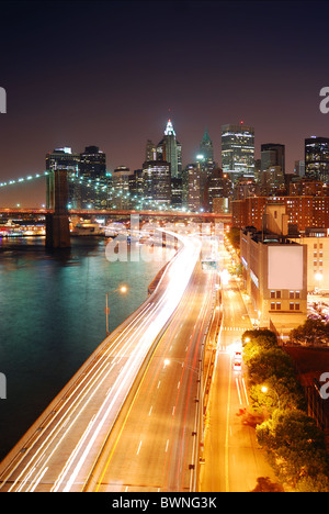 Skyline von New York City Manhattan und Brooklyn Bridge mit Wolkenkratzern über Hudson River mit Lichtern und verkehrsreichen beleuchtet Stockfoto