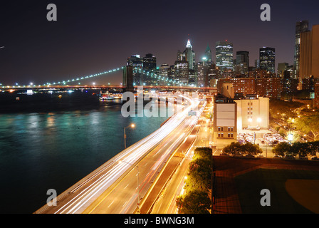 Skyline von New York City Manhattan und Brooklyn Bridge mit Wolkenkratzern über Hudson River mit Lichtern und verkehrsreichen beleuchtet Stockfoto