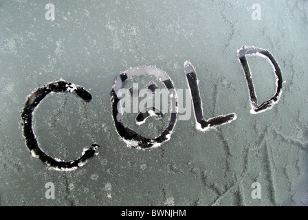 Das Wort "Kalte" geschrieben auf Frost/gefrostet Autofenster. Mit einem traurigen Gesicht gezeichnet in den Buchstaben "o '. Darstellung Einfrieren Eis Stockfoto