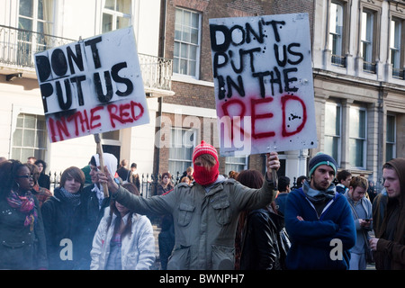 LONDON, ENGLAND - Studentendemonstration gegen Gebühr erhebt sich und Haushaltskürzungen in Whitehall, Studenten mit Plakaten Stockfoto